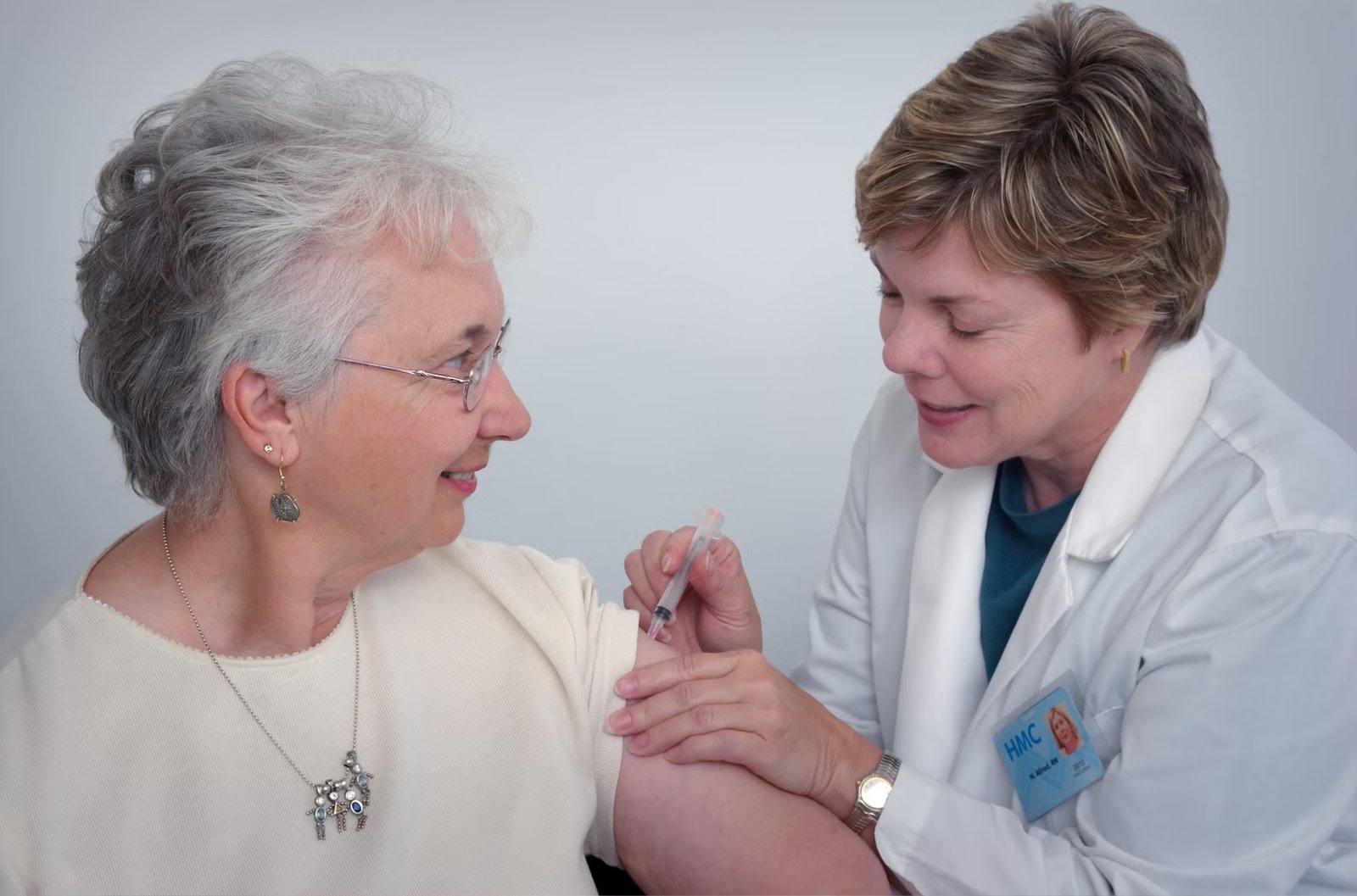 Female clinician giving a vaccine to a patient